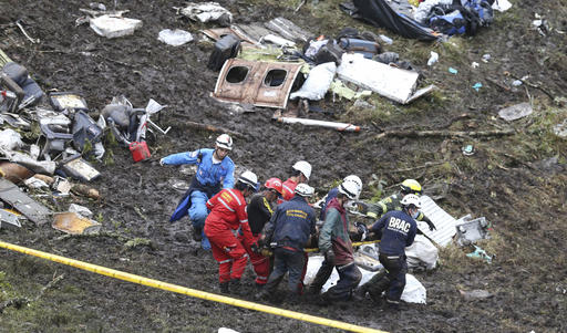 CORRECTS TO REMOVE DEATH TOLL OF 75 AFTER NUMBER OF DEATH TOLL WAS LOWERED BY COLOMBIAN OFFICIALS - Rescue workers recover a body from the wreckage site of an airplane crash, in La Union, a mountainous area near Medellin, Colombia, Tuesday , Nov. 29, 2016. The chartered plane was carrying a Brazilian soccer team to the biggest match of its history when it crashed into a Colombian hillside and broke into pieces, Colombian officials said Tuesday. (AP Photo/Fernando Vergara)