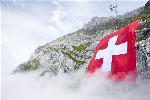 The world largest Swiss flag hangs at the ruggedly rock face of the mountain Saentis in Schwaegalp, Switzerland, Friday, July 31, 2009. The flag measures 120 meters to 120 meters and is the world second largest flag. Tomorrow  Aug. 1,  Switzerland is celebrating the national holiday. (AP Photo/Keystone/Ennio Leanza)