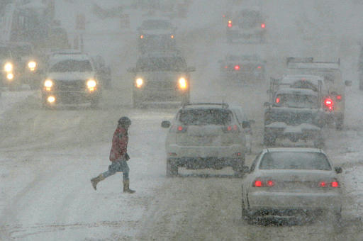 Through a blinding snow storm, a woman crosses the street in downtown Chagrin Falls, Ohio, Saturday morning, Jan. 22, 2005.  Northeast Ohio was expecting up to a foot of snow in the major winter storm. (AP Photo/Amy Sancetta)