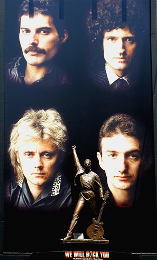 A bronze statue of Freddie Mercury, flanked by other members of the British rock group Queen, clockwise from top right, Brian May, John Deacon and Roger Taylor, looms over Japanese passersby at Tokyos  entertainment district of Shinjuku on Sunday April 24, 2005. The 3-meter tall (9.9-foot) bronze statue of Mercury, who died in 1991, marks the Japanese tour next month of the British musical, We Will Rock You, at the Shinjuku Koma Theater. (AP Photo/Shizuo Kambayashi)