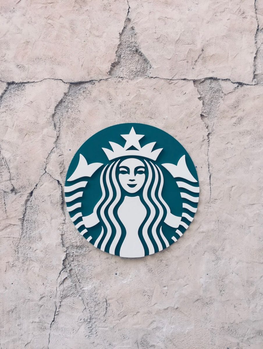Above, the Starbucks logo is placed on a wall. Photograph via Khadeeja Yasser on Unsplash.com.