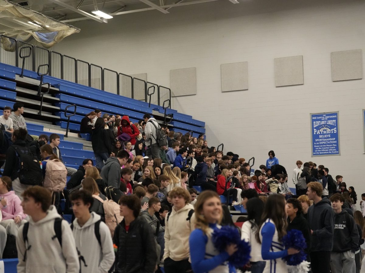 Students filtering in to the gym and getting ready to watch the game.