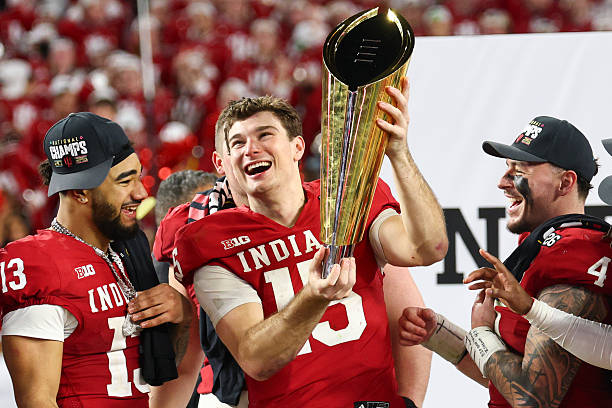 MIAMI GARDENS, FLORIDA - JANUARY 19: Fernando Mendoza #15 of the Indiana Hoosiers raises the National Championship Trophy after Indiana defeated the Miami Hurricanes 27-21 in the 2026 College Football Playoff National Championship at Hard Rock Stadium on January 19, 2026 in Miami Gardens, Florida. (Photo by Jamie Schwaberow/Getty Images)